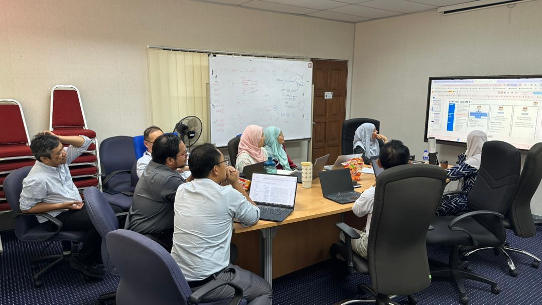 Cross-team review at NPRA HQ with project artefacts on tables and laptops open to working documents.